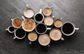 Many cups of different coffees on slate table, flat lay Royalty Free Stock Photo