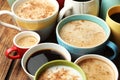 Many cups of different coffees on wooden table, closeup