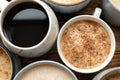 Many cups of different coffees on wooden table, flat lay