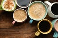 Many cups of different coffees on wooden table, flat lay