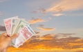 Many currency banknote on hand with twilight sky background