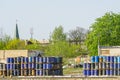 Barrels with chemical products in the port quay, church in the background Royalty Free Stock Photo