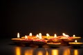many decorative diwali oil lamps glowing on dark background generative AI Royalty Free Stock Photo
