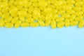 Many delicious lemon jelly beans on light blue background. Space for text