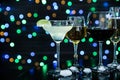 Many different alcoholic drinks on table against dark background with blurred lights Royalty Free Stock Photo