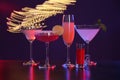 Many different alcoholic drinks on table against dark background with blurred lights Royalty Free Stock Photo