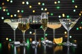 Many different alcoholic drinks on table against dark background with blurred lights Royalty Free Stock Photo