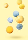 Many different bath bombs falling on pastel yellow background Royalty Free Stock Photo