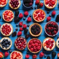 Many different berry tarts on blue wooden table, flat lay. Delicious pastries