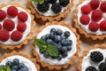 Many different berry tarts on , top view. Delicious pastries