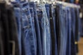 Many different blue Jeans on a hanging rack in the clothes shop store Royalty Free Stock Photo