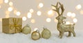 Banner with many different christmas items on white snow with many small, shining lights in the background