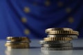 Many different coins on table against European Union flag. Space for text Royalty Free Stock Photo