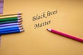 Many different colored pencils on yellow paper with the words, Black lives matter for stop racism concept, justice background Royalty Free Stock Photo