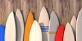 Many different colored surfboards standing in a row on a wooden wall