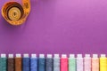 Many different colorful sewing threads and a measuring tape on a purple background Royalty Free Stock Photo