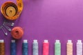 Many different colorful sewing threads and a measuring tape on a purple background Royalty Free Stock Photo