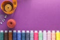 Many different colorful sewing threads and a measuring tape on a purple background Royalty Free Stock Photo