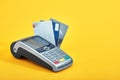 Many different credit cards and payment terminal on yellow background, closeup