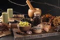 Many different dry herbs, flowers and mortar with pestle on dark grey table Royalty Free Stock Photo