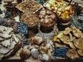 Many different edible mushrooms in baskets on food market.