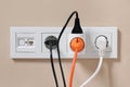 Many different electrical power plugs in sockets on beige wall Royalty Free Stock Photo