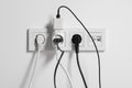 Many different electrical power plugs in sockets on light wall Royalty Free Stock Photo