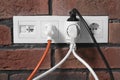 Many different electrical power plugs in sockets on red brick wall Royalty Free Stock Photo