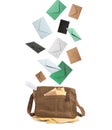 Many different envelopes falling into brown postman`s bag on white background Royalty Free Stock Photo