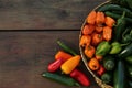 Many different fresh chilli peppers on wooden table, flat lay. Space for text Royalty Free Stock Photo