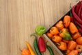 Many different fresh chilli peppers on wooden table, flat lay. Space for text Royalty Free Stock Photo