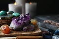 Many different gemstones and blurred candles