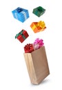 Many different gift boxes falling into paper shopping bag on white background Royalty Free Stock Photo