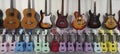 many different guitars and ukuleles on a stand in a music store Royalty Free Stock Photo