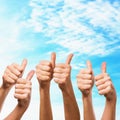 Many different hands with thumb raised up, against the background of the sky with a copy of space. Symbol of approval and consent