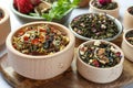 Many different herbal teas in bowls on table, closeup Royalty Free Stock Photo