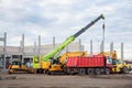 Many different multiclored colorful heavy industrial machinery equipment at construction site parking area against