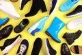 Many different pairs of shoes for different seasons. a lot of shoes on yellow background, top view. Royalty Free Stock Photo