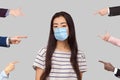 Many different people hands are pointing on guilty alone young woman with surgical medical mask and blame her. she looking at Royalty Free Stock Photo