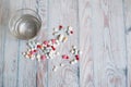 Many different pills water glass on blue wooden background