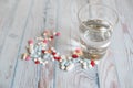 Many different pills water glass on blue wooden background