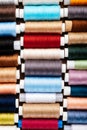 Many different reels with threads, flat lay, top view. Colored threads, close-up, bright background. Cutting and sewing clothes