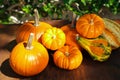 Many different ripe orange pumpkins on wooden table outdoors Royalty Free Stock Photo