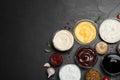Many different sauces on black table, flat lay. Space for text Royalty Free Stock Photo