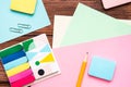 Many different school supplies, sheets of colored paper, pencil, paper clips on a wooden background. Flat lay. Royalty Free Stock Photo