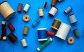 Many spools of thread on blue background. Royalty Free Stock Photo