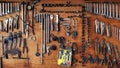 Many different sizes of tools, wrenches and pliers hanging on wooden panel background. Royalty Free Stock Photo