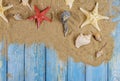 Many different star fish and shells in the sand beach on a blue wooden background Royalty Free Stock Photo