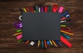 Many different stationery on a wooden surface under a dark gray sheet of paper. Flat lay. Gray empty space for text. Royalty Free Stock Photo