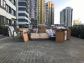 Many different things of furniture stand unloaded on the street near the house of the skyscraper new building. Concept: relocation